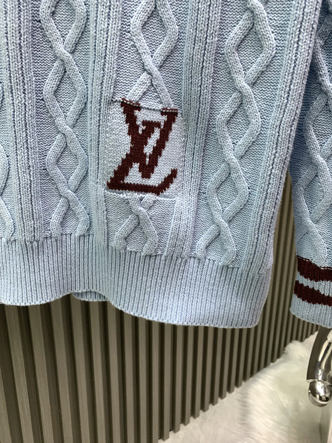 🅿️380 🀄️ Louis Vuitton 25* new autumn and winter cable knitted sheep wool and mohair V-neck pullover This cable knitted V-neck sweater is made of fine mohair and sheep wool, making the scalloped hem of the sleeves complement the wavy intarsia lines on the cuffs and collar. The contrasting 1V intarsia hem on the left adds a college atmosphere to the early spring look. Made of blended wool yarn, 30% wool and 70% acrylic dyed yarn. The process is complex and requires 180 points/piece. This style uses 7-needle Juxin woven pieces. 9 yarn feeders are needed to hang the wool on the front. The whole piece is moved to twist the rope. The intersection of the twisted ropes is prone to holes. The coffee-colored part of the yarn is mohair. The machine adjustment time is long. The needles added at the bottom of the sleeve clips are all edged, which increases the loom time and sewing time. Because the logo is hung with hair, the coffee-colored thread is clamped on the edge and needs to be drawn out. Moreover, due to the characteristics of mohair, hair will fall out when drawing out the thread. It is necessary to manually remove the stray hairs bit by bit, which is very time-consuming. Customized accessories, complete with three standards, same style for men and women.